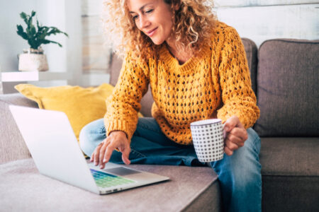 Woman using laptop with cup of coffee giving a testimonial online