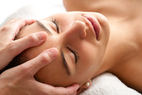 Young woman having osteopathy for headache