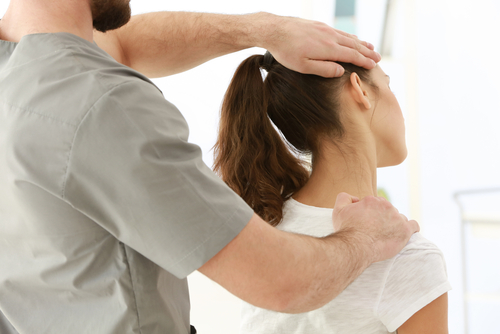 Osteopath treating woman for headache